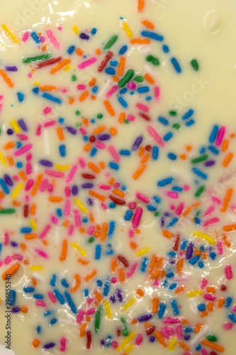 This is a photograph of White chocolate topped with colorful sprinkles