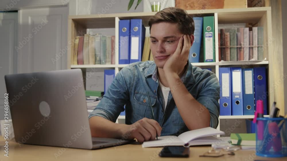 Bored young man business sales manager getting bored of dull paperwork suffering lack of motivation working in the office. Bored young man business sales manager getting bored of dull paperwork suffering lack of motivation working in the office.
