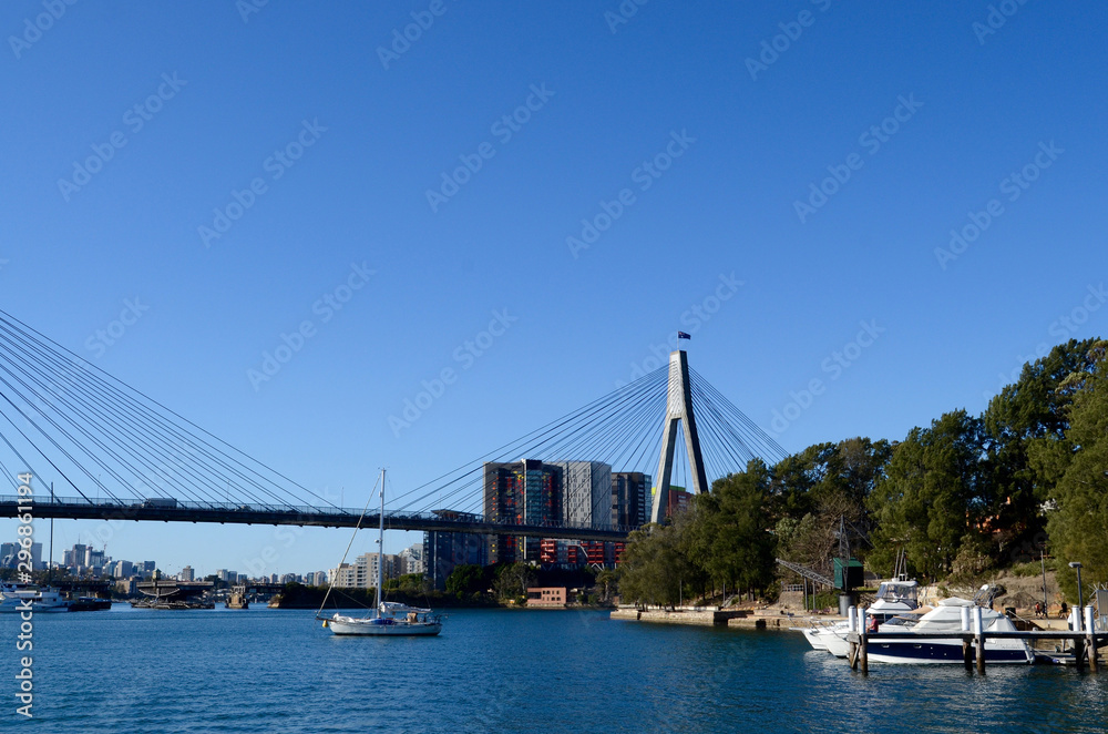 Obraz premium A view of Sydney's inner harbour shoreline with the Anzac Bridge in the background.