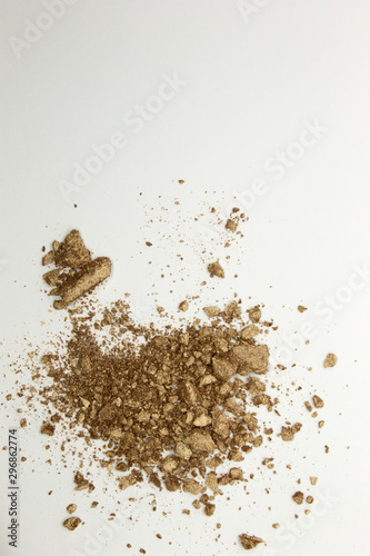 This is a photograph of a shimmery golden powder eyeshadow isolated on a White background