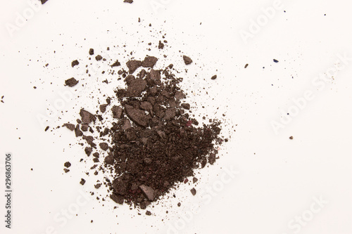 This is a photograph of a dark Brown powder Eyeshadow isolated on a White background