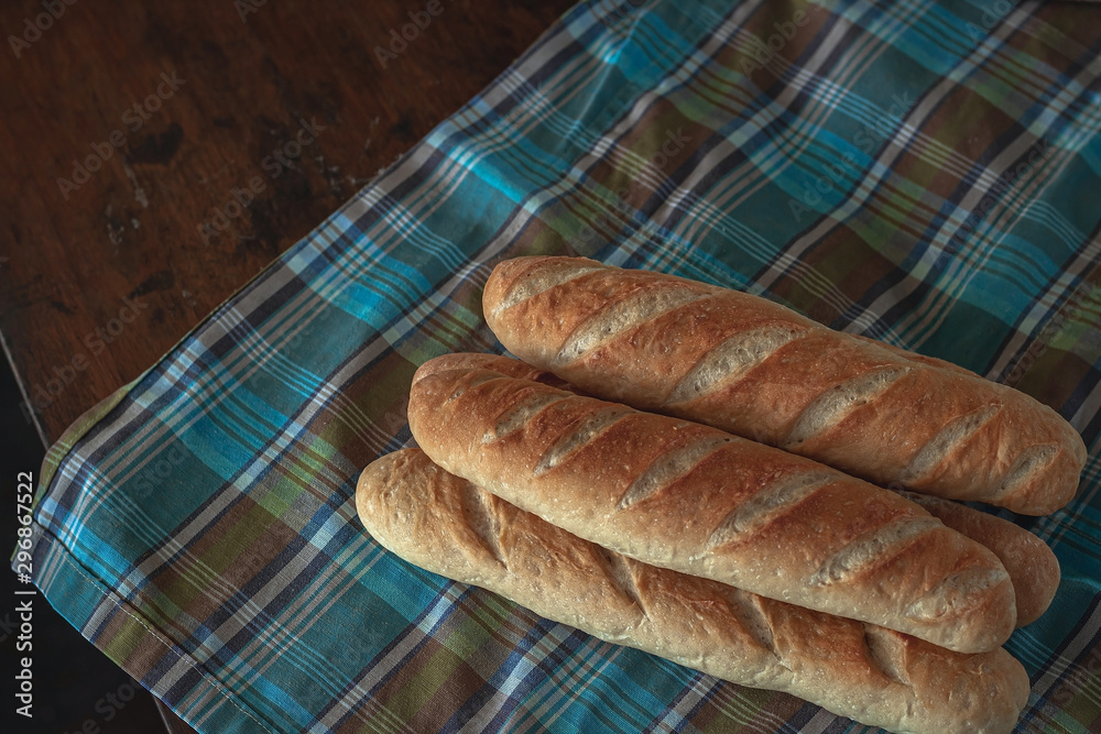 Baguette bread on a wooden table cloth.