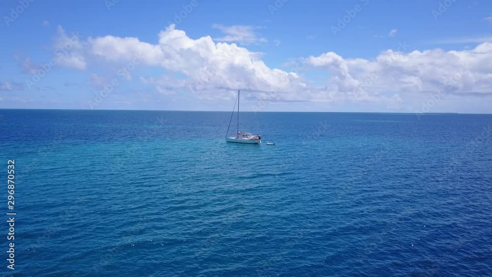Drone view, flying toward to a white yacht on turquoise blue water near shore of Saint Kitts and Nevis island Drone view, flying toward to a white yacht on turquoise blue water near shore of Saint Kitts and Nevis island
