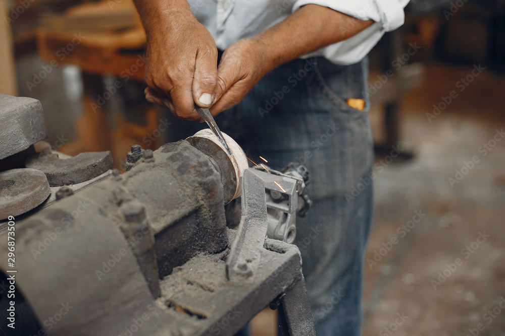 Man working with a wood. Carpenter in a white shirt Man working with a wood. Carpenter in a white shirt