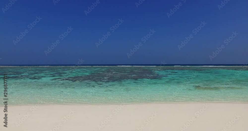 Steady shot of coral reefs and atolls in the tropical sea between white sand and blue sky horizon in Cagdanao, Philippines Steady shot of coral reefs and atolls in the tropical sea between white sand and blue sky horizon in Cagdanao, Philippines