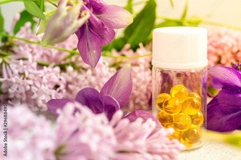 a jar with fish oil capsules and purple liliac flowers a jar with fish oil capsules and purple liliac flowers