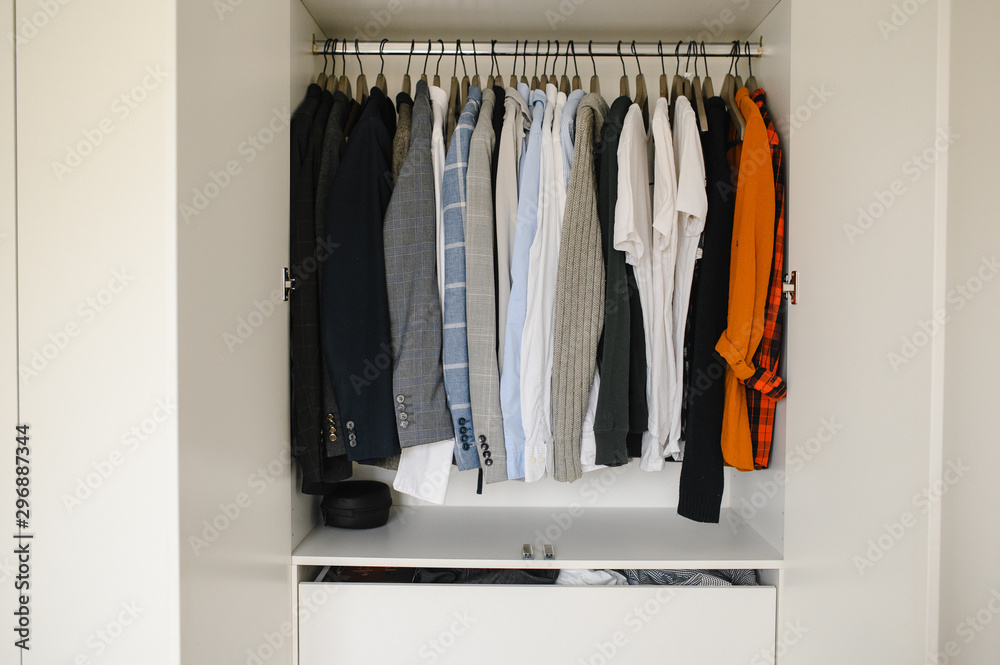 Many man's clothes in wardrobe, closeup. White wardrobe Many man's clothes in wardrobe, closeup. White wardrobe
