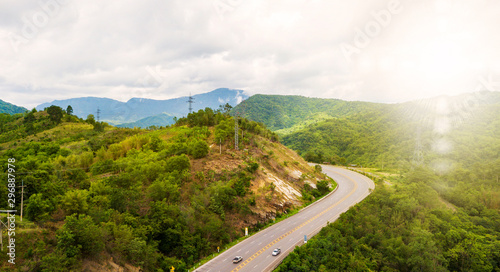 Aerial Landscape of Roads, travel routes in natural tourism in Thailand, paths cut through beautiful mountain forests And with the sky and sunshine as the background.