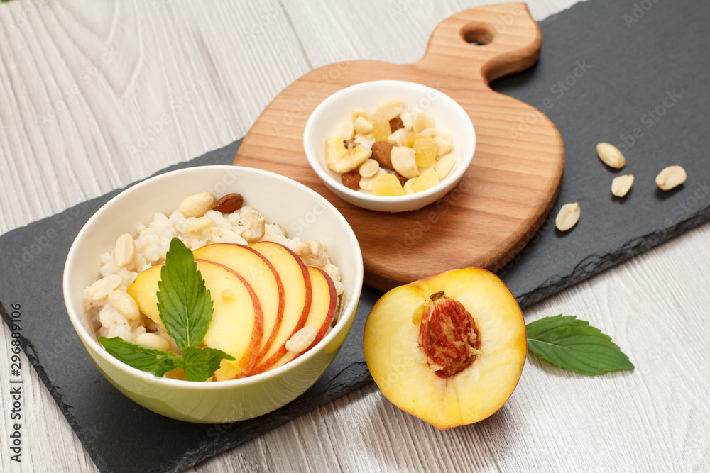 Sorghum salad with nuts and fresh peach on stone board.