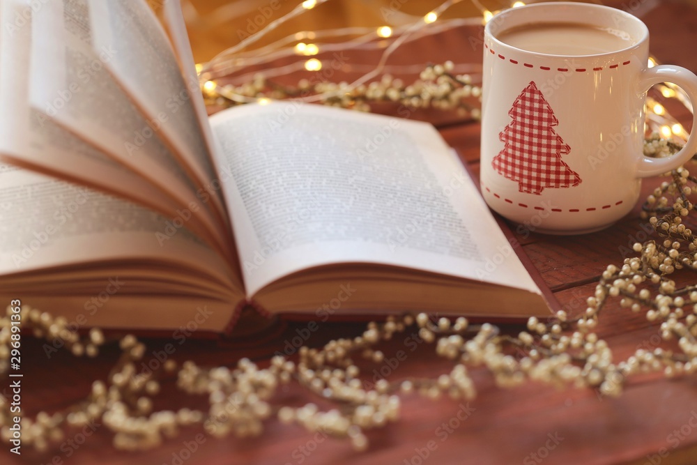 Christmas cup of tea with a Christmas tree ,Book , Vintage garland on a red wooden background. Books about Christmas. Winter Tea. Christmas cup of tea with a Christmas tree ,Book , Vintage garland on a red wooden background. Books about Christmas. Winter Tea.