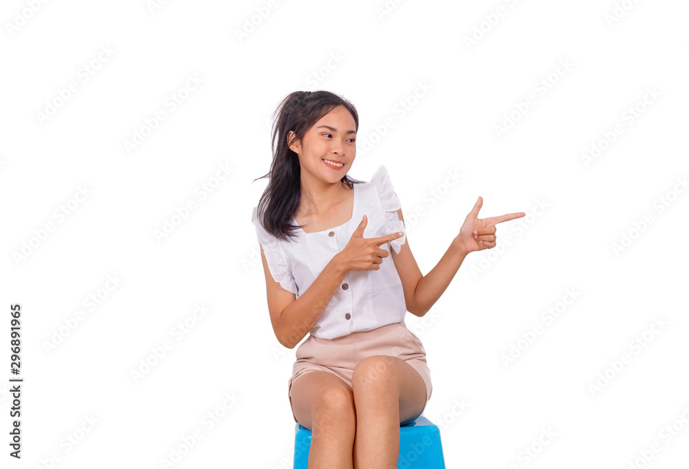An asian girl in white sitting on blue stool and pointing to the right side An asian girl in white sitting on blue stool and pointing to the right side