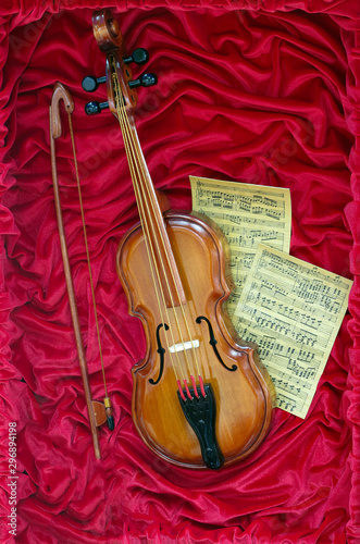 Violin concept and sheet music on red canvas