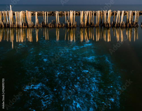 Foto A beautiful scene of illuminate bioluminescent plankton glow blue fluorescent in night sea water at Red Bridge (Saphan Daeng) , Samut Sakhon near Bangkok Thailand