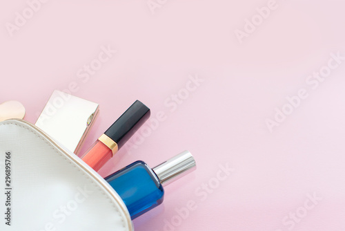 Fototapeta Naklejka Na Ścianę i Meble -  Cosmetic bag with a minimum set of cosmetics on a pink background. Minimalism concept. 
