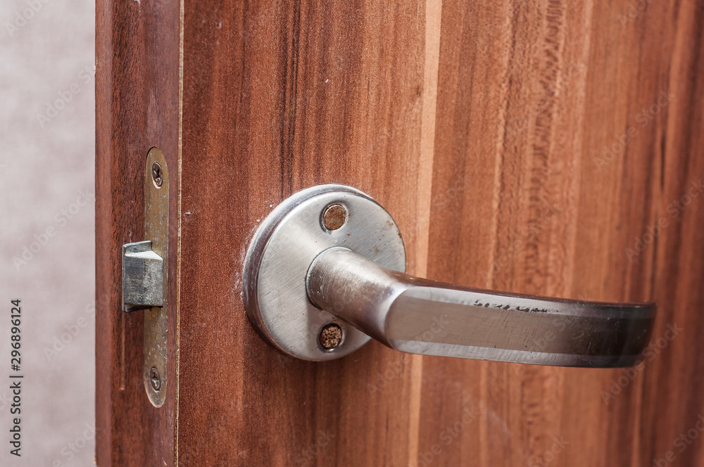 The handle of the entrance door to the brown toilet made under the tree.