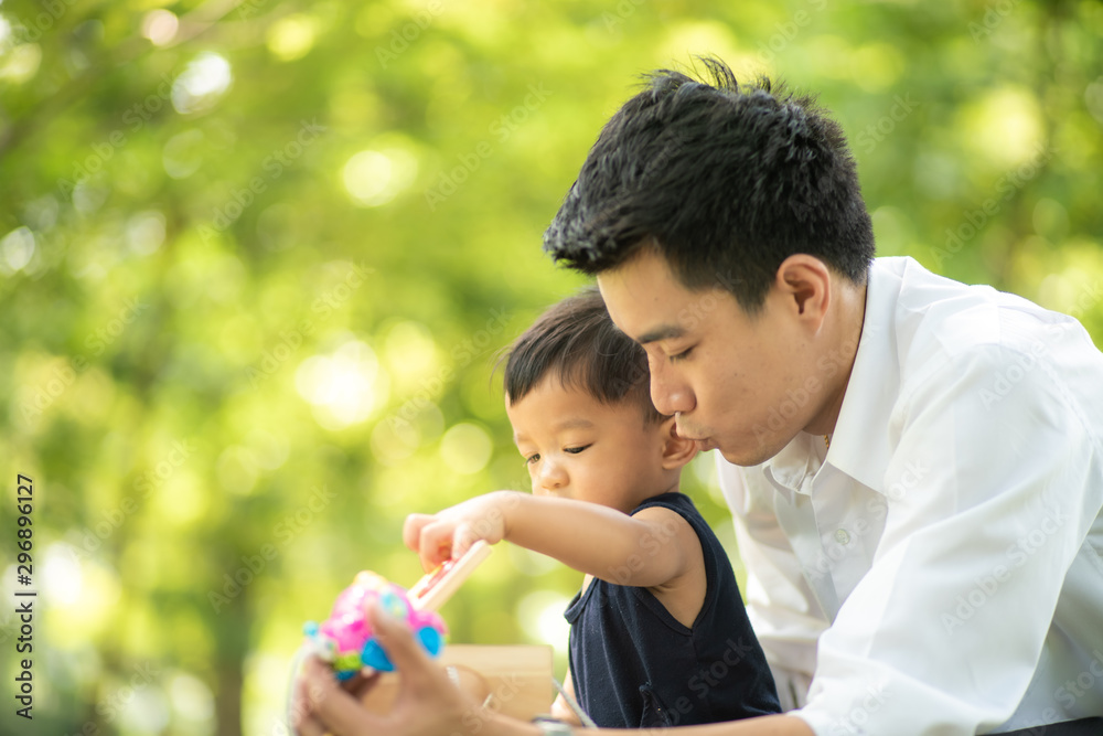 Father playing with baby boy after working in city park Father playing with baby boy after working in city park