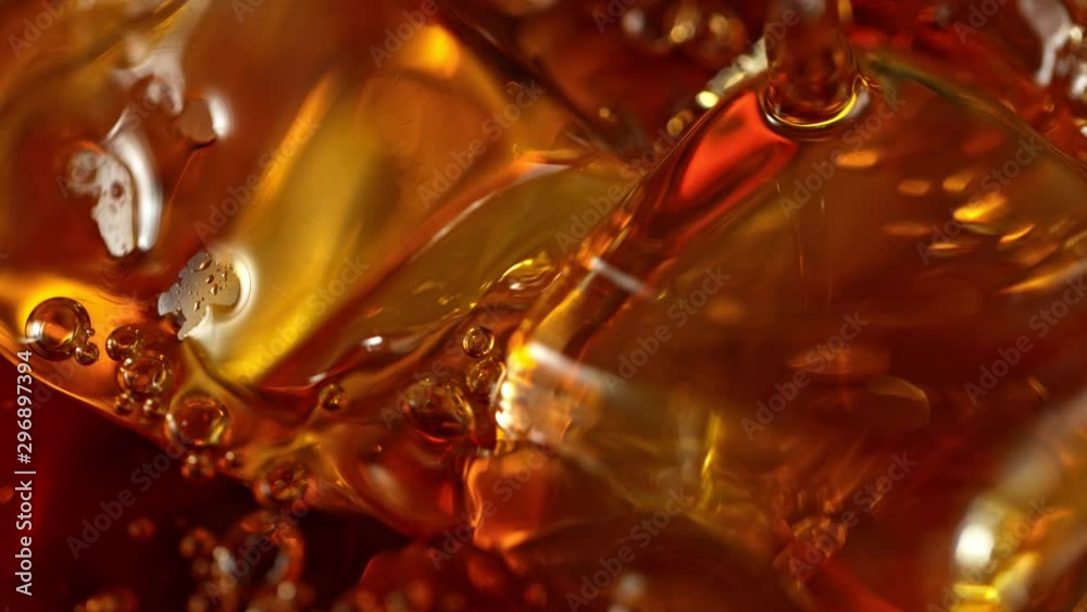 Super Slow Motion Macro Shot of Pouring Whiskey into Glass with Ice Cubes at 1000fps. Filmed on High Speed Cinema Camera in 4K. Super Slow Motion Macro Shot of Pouring Whiskey into Glass with Ice Cubes at 1000fps. Filmed on High Speed Cinema Camera in 4K.