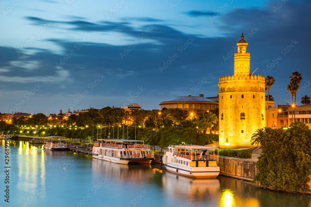 Obraz premium The Golden Tower (Torre del Oro) in Seville, Spain, is located at the margin of the Guadalquivir river and was built in the XIII century by the muslims ruling the area at the time.