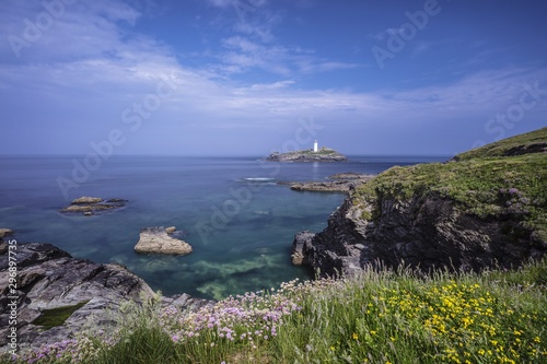 Beautiful scenery of the ocean with big rocks on the side in Godrevy, Cornwall, UK photo