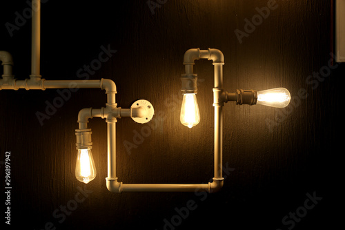 Edison Lamp and copper tubes on the dark background in the cafe in Tbilisi Georgia on October 2019. photo