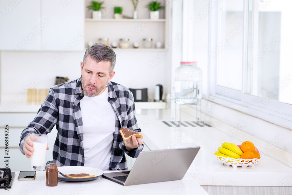 Man eating breakfast while working in the kitchen Man eating breakfast while working in the kitchen