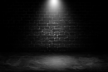 Abstract image of Spot lighting with black brick wall in background.