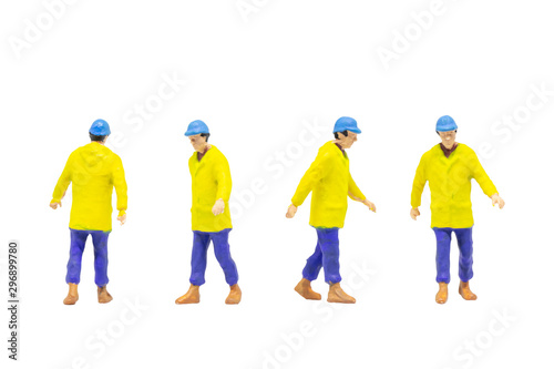 Miniature figurine character as worker wearing protective clothes and posing in posture isolated on white background.