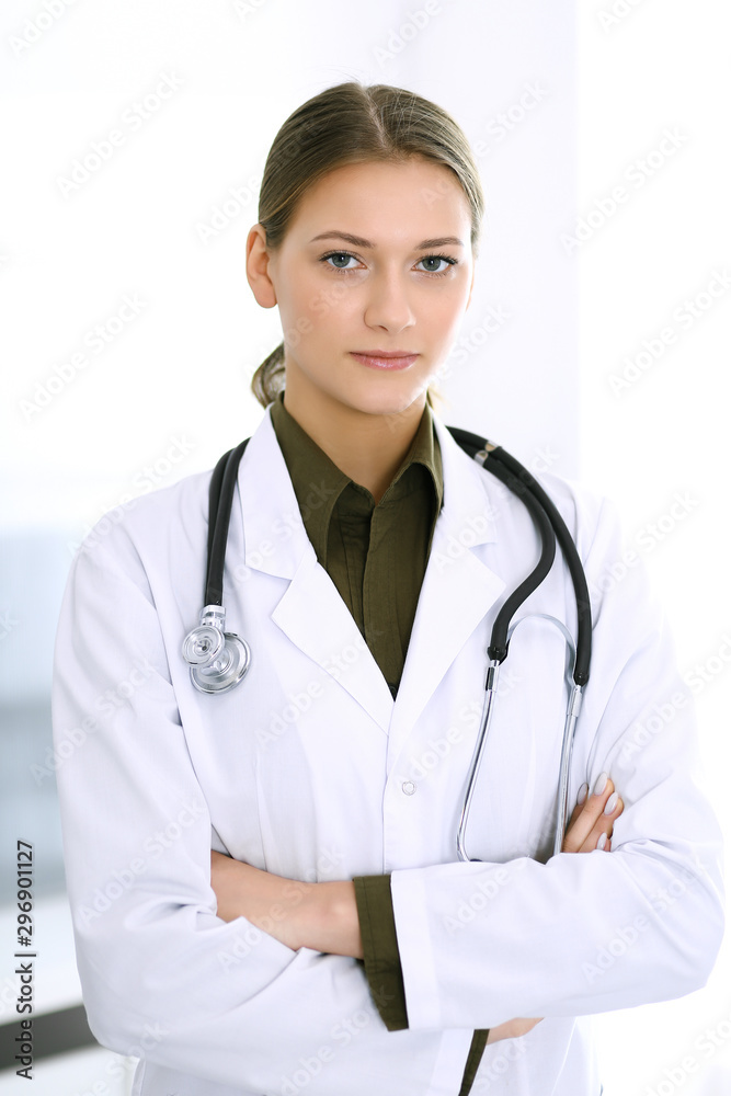 Doctor woman standing straight and looking at camera. Perfect medical service in clinic. Happy future in medicine and healthcare Doctor woman standing straight and looking at camera. Perfect medical service in clinic. Happy future in medicine and healthcare