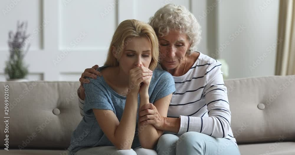 Caring senior mother consoling upset depressed young adult daughter Caring senior mother consoling upset depressed young adult daughter