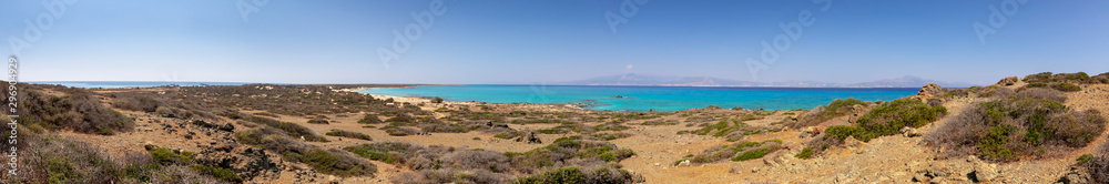 amazing panorama from a desert to a nice gulf , beach , rocks and deep azure sea and high mountains and blue sky on the background. Greek landscape.