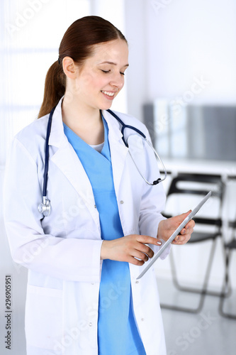 Doctor woman or intern student at work. Physician using tablet computer while standing in emergency hospital office. Data in medicine and health care concept