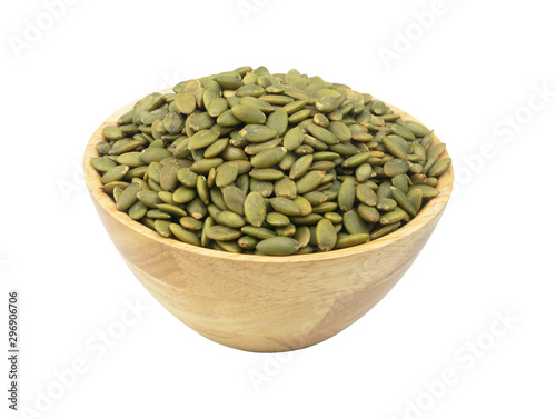 Pumpkin seeds in wooden bowl isolated on white