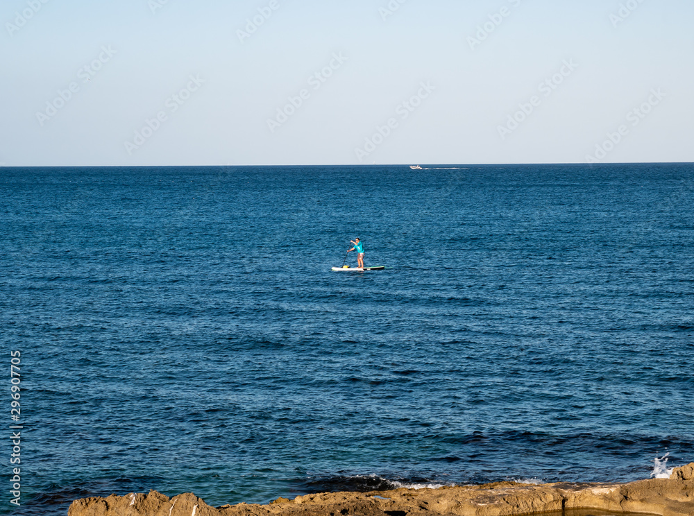 Naklejka premium man doing paddle surf in the sea
