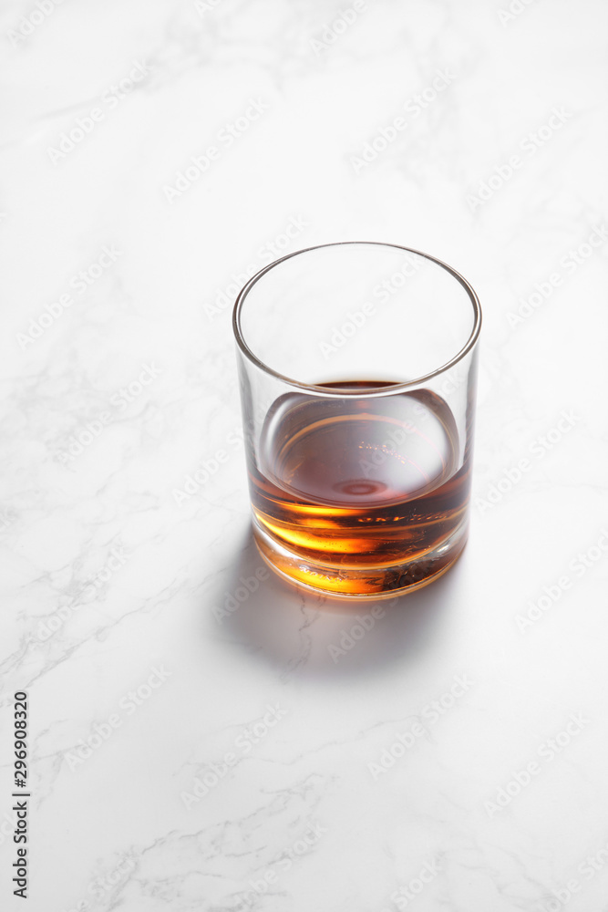 scotch whiskey in glass on a white marble table with a blank space for a text, scotch whiskey in bar background scotch whiskey in glass on a white marble table with a blank space for a text, scotch whiskey in bar background