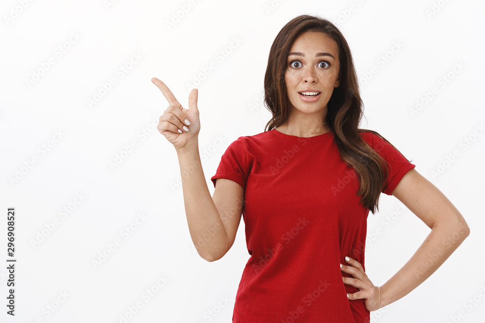 Surprised and intrigued young attractive woman with brown hair, freckles looking impressed and ambushed, asking question about cool promo, pointing upper left corner, gasping adoration and interest Surprised and intrigued young attractive woman with brown hair, freckles looking impressed and ambushed, asking question about cool promo, pointing upper left corner, gasping adoration and interest