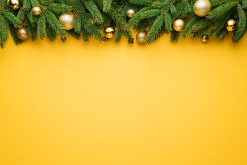 Christmas yellow background with fir tree border and decoration