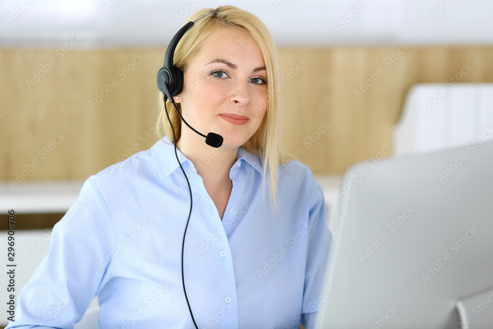 Call center. Blonde business woman sitting in headset at customer service office. Concept of telesales business or home office occupation Call center. Blonde business woman sitting in headset at customer service office. Concept of telesales business or home office occupation