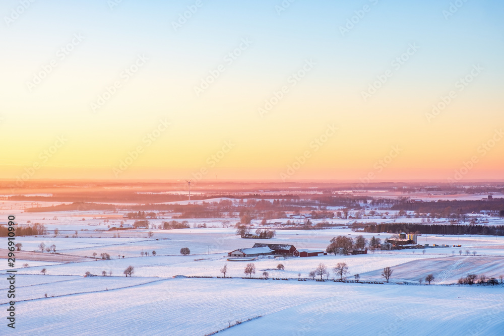 Wintery sunset over a rural landscape with fields and farms Wintery sunset over a rural landscape with fields and farms