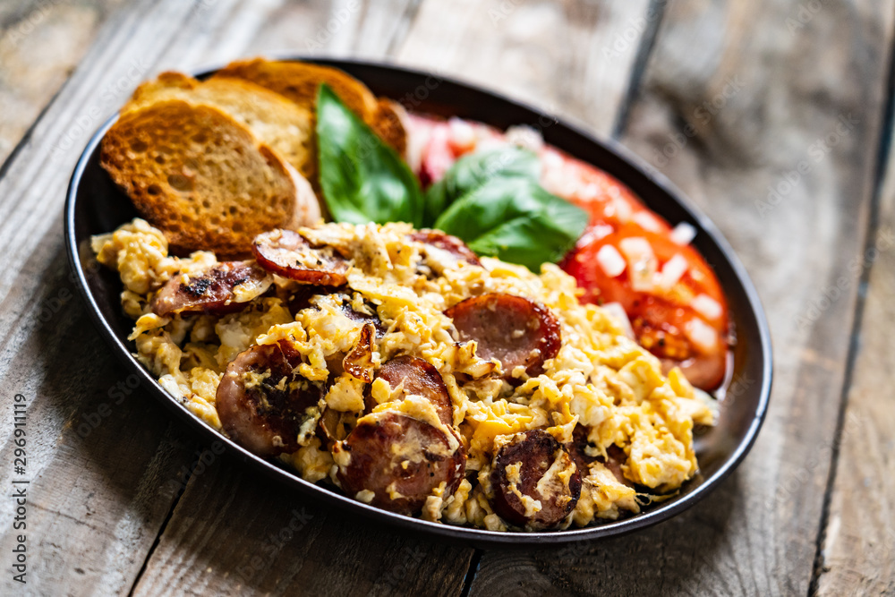Breakfast - scrambled eggs with sausage and toasts Breakfast - scrambled eggs with sausage and toasts