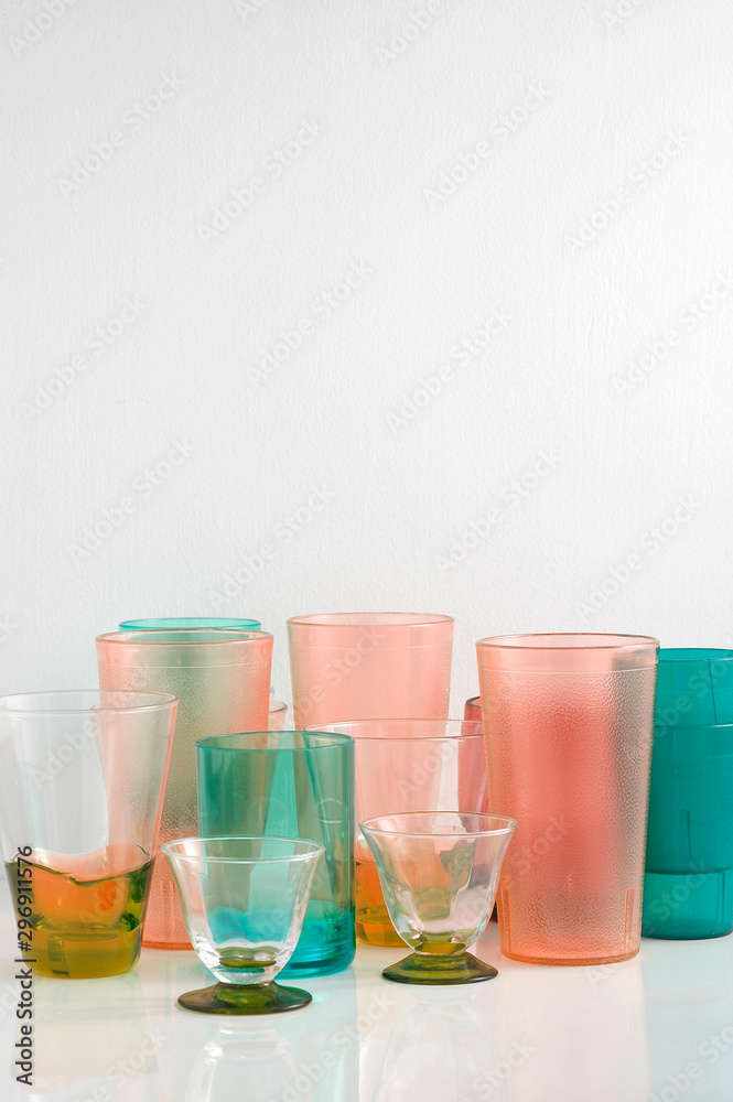Group of various color glass on white table with a blank space for a text, glass on white background Group of various color glass on white table with a blank space for a text, glass on white background