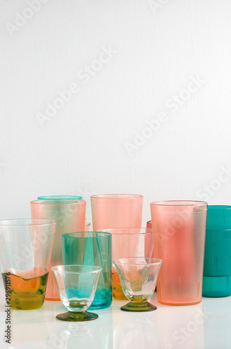 Group of various color glass on white table with a blank space for a text, glass on white background