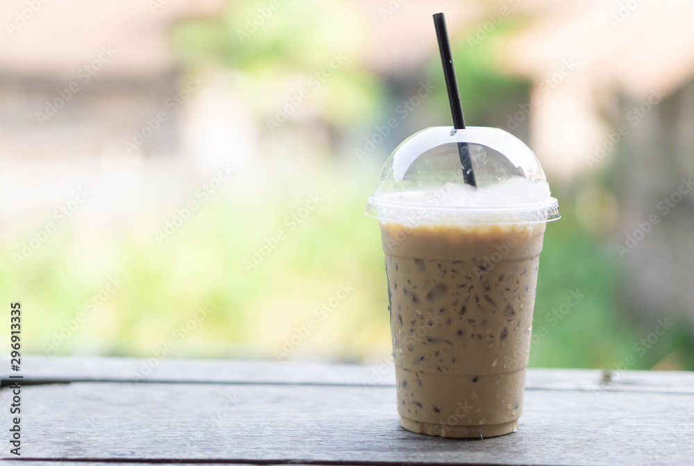 Closeup ice coffee on wood table with nature background Closeup ice coffee on wood table with nature background