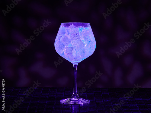 Gin tonic under blacklight (UV) illumination. Glow in the dark drink.   