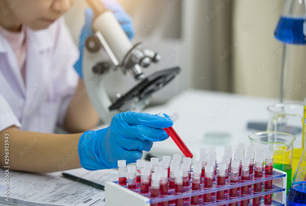 Lab worker putting medical blood sample in place after examining for sediments Lab worker putting medical blood sample in place after examining for sediments