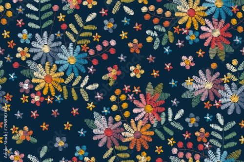 Embroidery seamless pattern with floral motifs. Colorful flowers, leaves and berries on dark blue background.