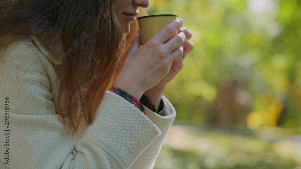 Young girl holding in hands cup of hot tea, sitting on stairs in outdoors autumn park, beautiful woman enjoy drinking cup of coffee thermos, lifestyle relax weekend meditation concept Young girl holding in hands cup of hot tea, sitting on stairs in outdoors autumn park, beautiful woman enjoy drinking cup of coffee thermos, lifestyle relax weekend meditation concept