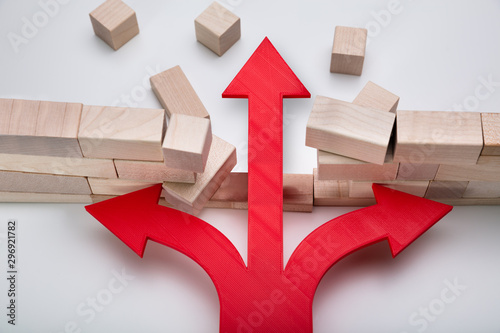 Fotografía Arrow Breaking Through Wall Made Of Wooden Blocks