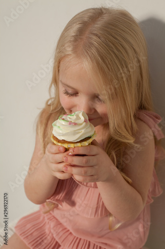 Little girl eats sweet cake with cream