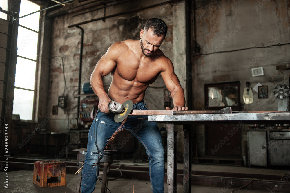 Muscled half naked man at work in an old factory. Stock Photo | Adobe Stock