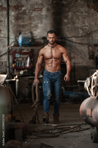 Obraz na płótnie Muscled half naked man at work in an old factory. w salonie